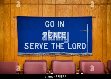 `Go in Peace Serve the Lord` written on Dark Blue Cloth with white cross on the right side, tassels all along the bottom of the cloth. Stock Vector